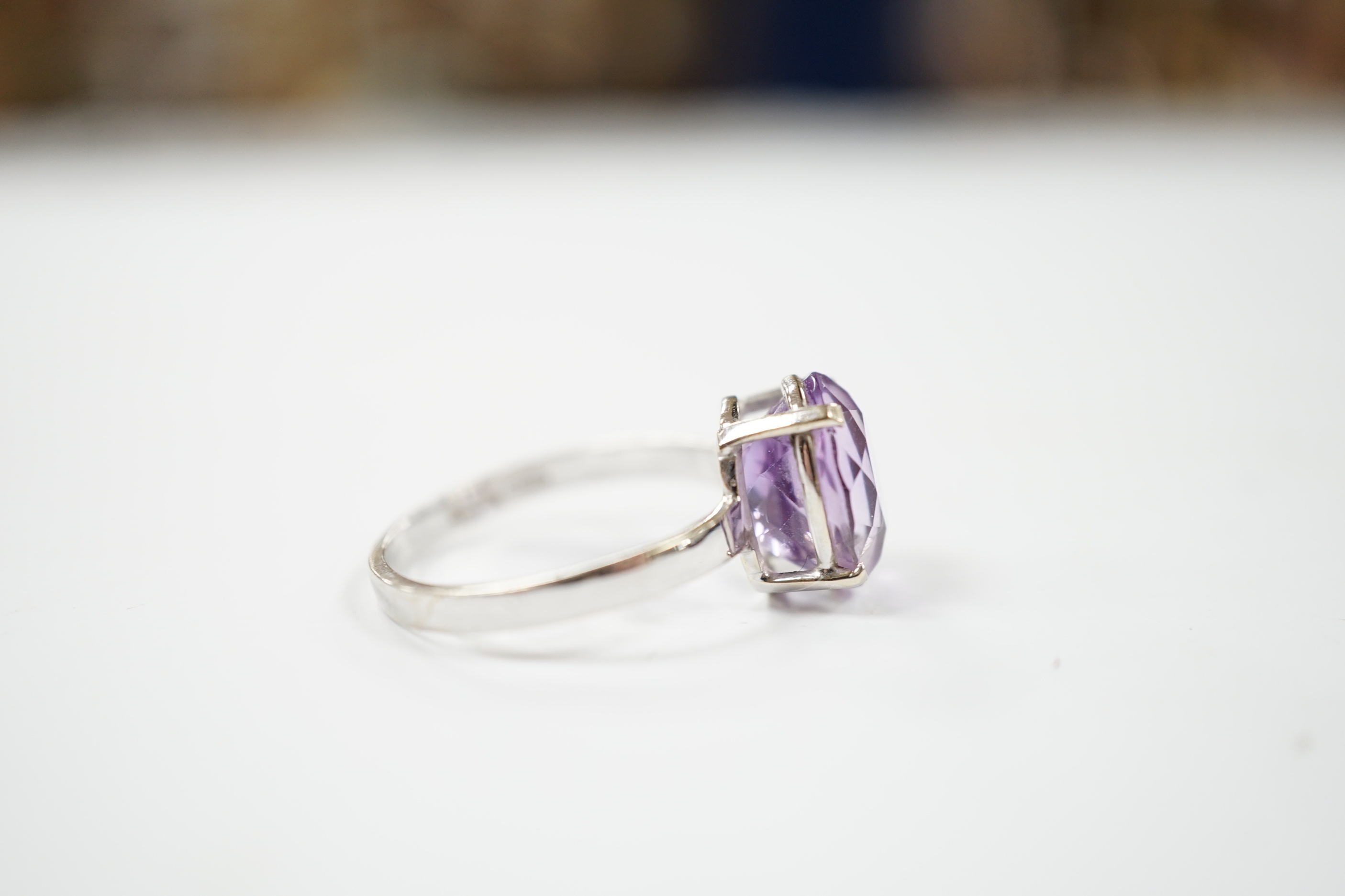 A 750 white metal and oval cut amethyst set ring, size O/P, gross weight 3.1 grams.